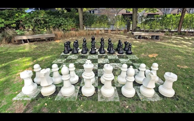 Giant chess pieces arranged on board outdoor area exterior at Griffon Studios in London Student Accommodation