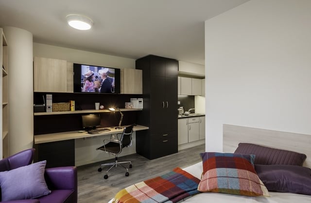 Desk TV shelves and kitchen student studio room at The Lyra in London Student Accommodation