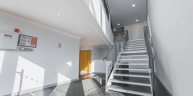 Staircase with metal railings and yellow doors Interior at The Bank Leicester in Leicester Student Accommodation