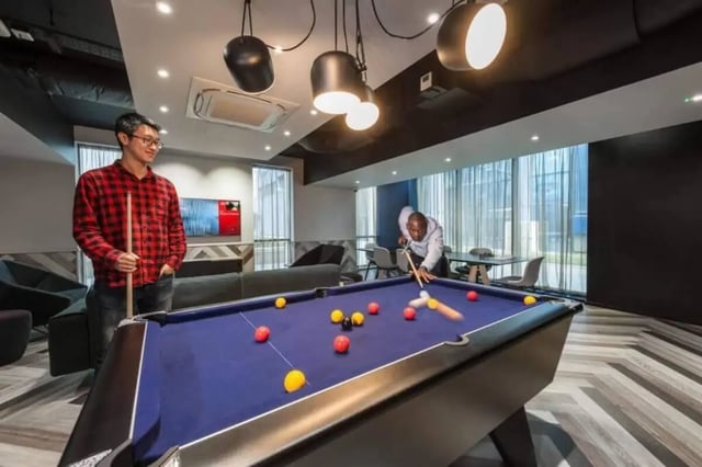Pool table with people playing playing area at CitySide in Leeds Student Accommodation