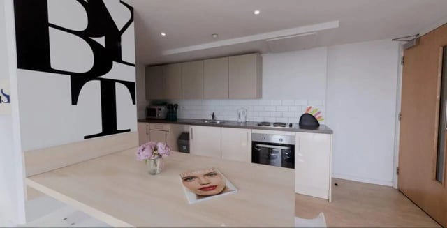 Modern kitchen with dining table and large art. at The View - Newcastle in Newcastle Upon Tyne Student Accommodation