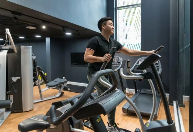 Man on elliptical trainer in gym fitness area at Verde in Newcastle Upon Tyne Student Accommodation
