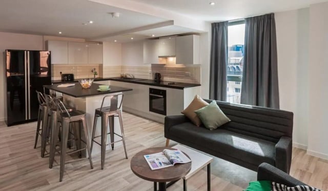 Black fridge kitchen island sofa living room at City Village in Coventry Student Accommodation