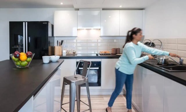 Modern kitchen with a person washing dishes kitchen at City Village in Coventry Student Accommodation