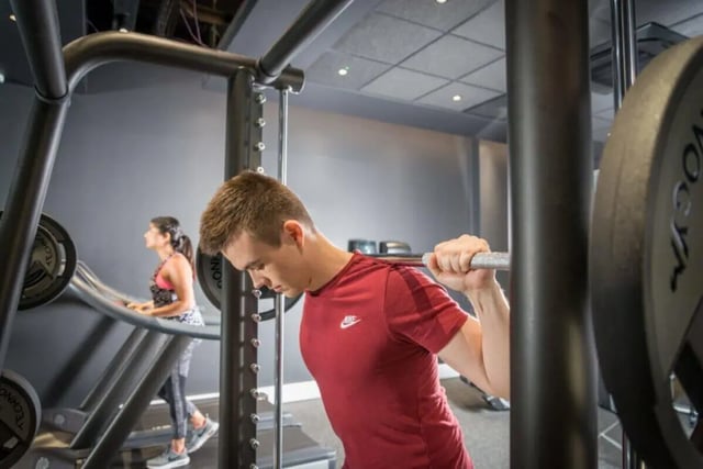Man squats weights woman uses treadmill gym at City Village in Coventry Student Accommodation