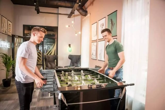 Two students play foosball in a common room at City Village in Coventry Student Accommodation