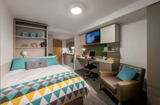 Bed desk chair armchair and kitchen studio room at West View in Glasgow Student Accommodation