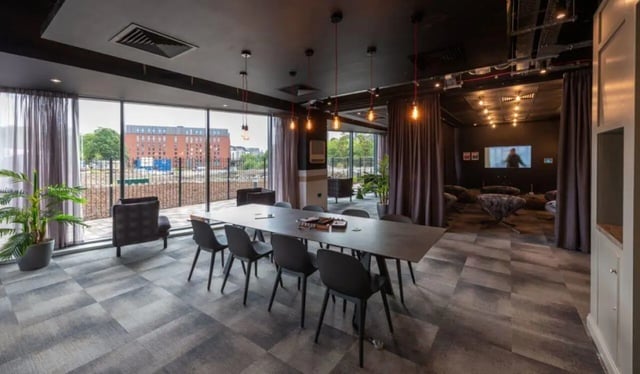 Dining table chairs plant large window living room at West View in Glasgow Student Accommodation
