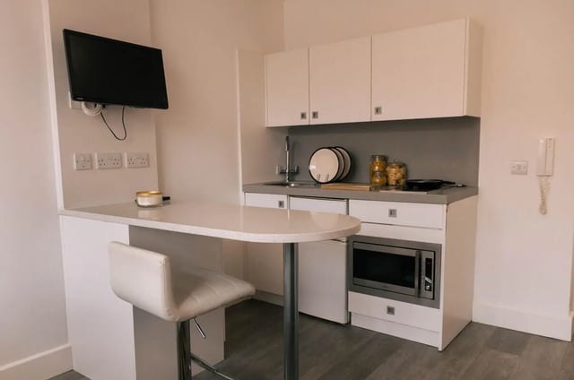 White breakfast bar with stool and kitchenette kitchen at Stonebridge House in Bristol Student Accommodation