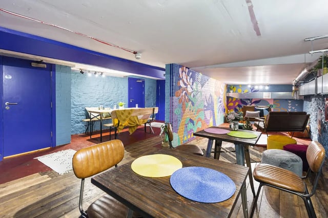 Dining area with tables chairs and colorful mural Living room at Tamarillo House in Bristol Student Accommodation