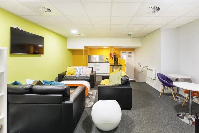 Sofas kitchen area television and tables communal area at Tamarillo House in Bristol Student Accommodation