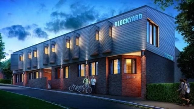 Modern building with bicycles and people exterior at Blockyard Apartments in Exeter Student Accommodation