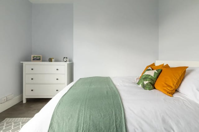 White dresser pillows green throw bed bedroom at Holgate Road in York Student Accommodation
