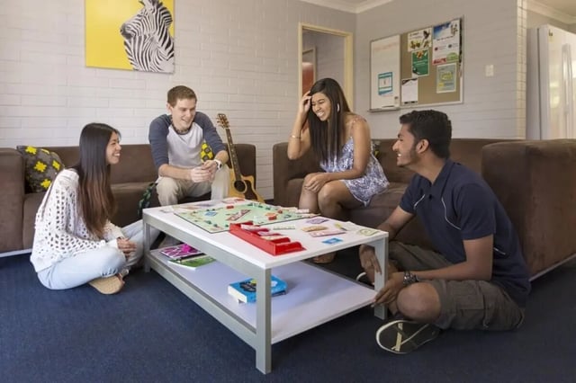Students playing board game on coffee table living room at Murdoch University Village in Perth Student Accommodation