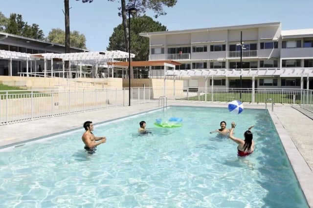 Students playing volleyball in the swimming pool exterior at Murdoch University Village in Perth Student Accommodation