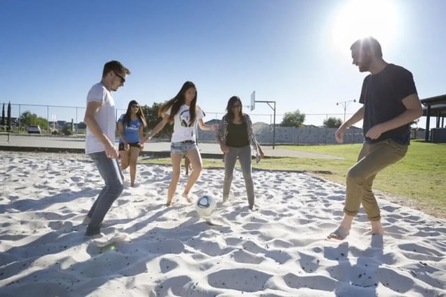 People playing soccer on sand outdoor court at Murdoch University Village in Perth Student Accommodation