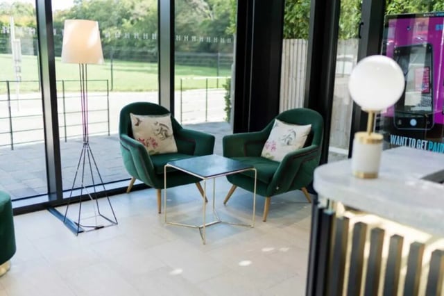 Two green armchairs with cushions and table common area at Hox Park in Egham Student Accommodation