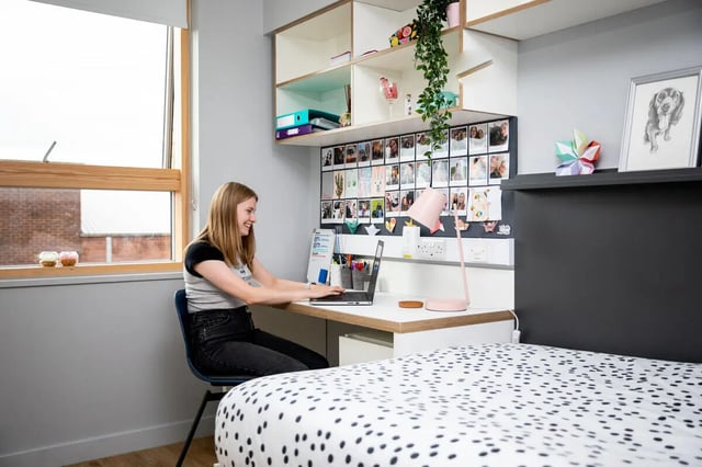 Student working at desk with laptop and photos Bedroom at The Depot in Bath Student Accommodation