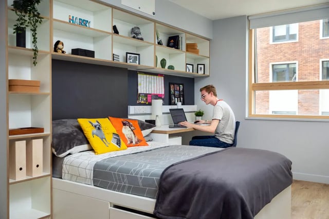 Student uses laptop at desk beside bed Bedroom at The Depot in Bath Student Accommodation