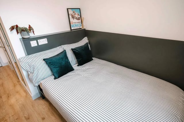 Striped bed with pillows and framed poster Bedroom at The Depot in Bath Student Accommodation