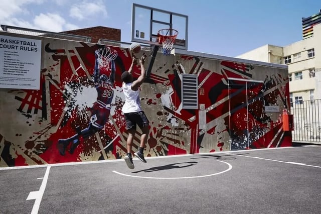 Basketball court with mural and players playing basketball court at Student Village - University of Melbourne Campus in Melbourne Student Accommodation