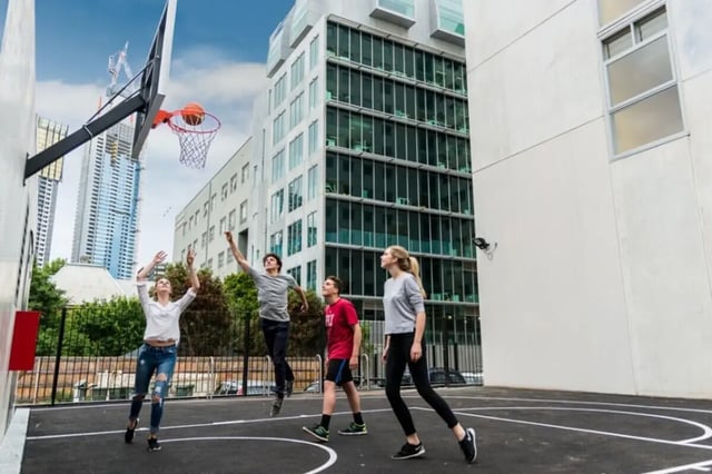 Students playing basketball near apartment buildings exterior at Student Village - University of Melbourne Campus in Melbourne Student Accommodation