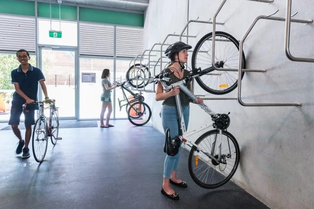 Bicycles on wall racks with students in room. at Student Village - University of Melbourne Campus in Melbourne Student Accommodation