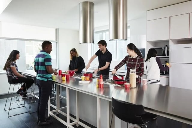 Students cooking and talking in a modern kitchen at Student Village - University of Melbourne Campus in Melbourne Student Accommodation