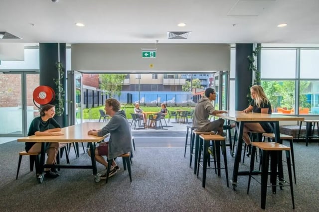 People sitting at tables communal area interior at Student Village - University of Melbourne Campus in Melbourne Student Accommodation