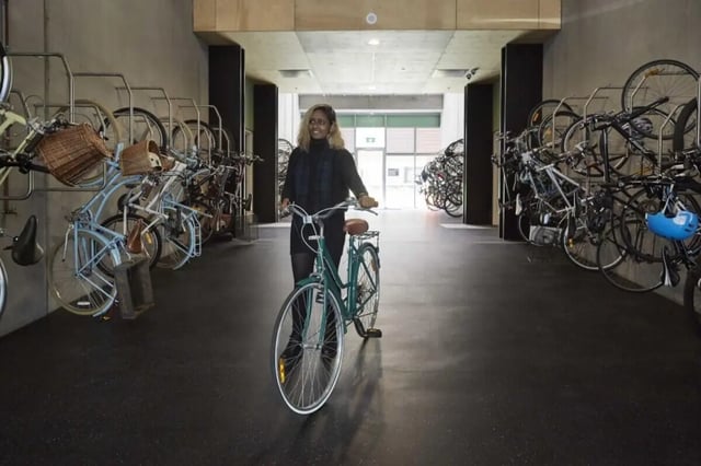 Student pushing bicycle in bicycle storage area at Student Village - University of Melbourne Campus in Melbourne Student Accommodation