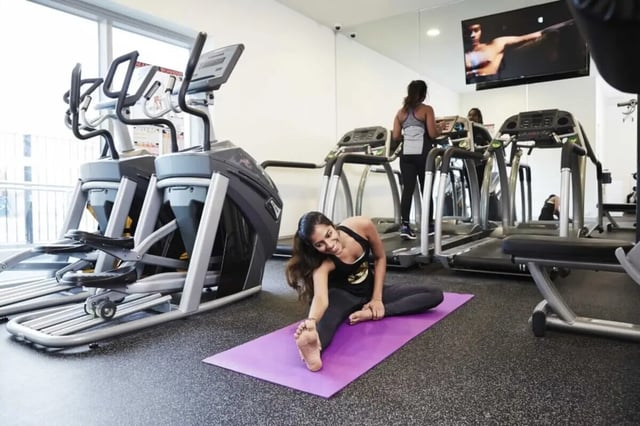 Women stretching on yoga mat gym equipment gym at Student Village - University of Melbourne Campus in Melbourne Student Accommodation