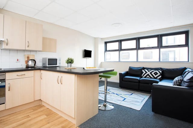 Kitchen counter with microwave sofa and bar stool living room at The Grange Leicester in Leicester Student Accommodation
