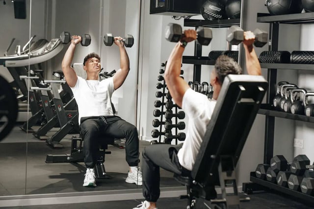 Man lifting weights on bench gymnasium Image Type at Alma Court in Canterbury Student Accommodation