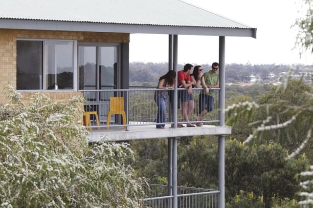 Four students standing on balcony exterior at ECU Village Bunbury in Bunbury Student Accommodation