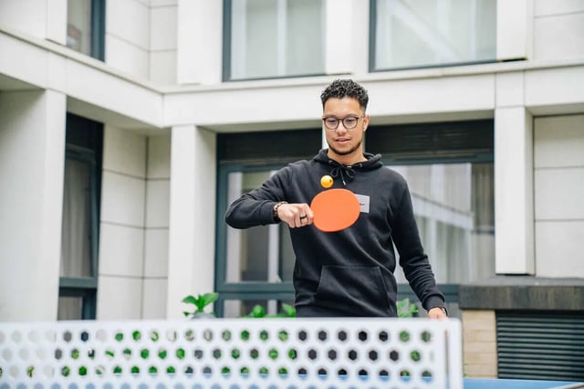 Man playing table tennis in student accommodation courtyard exterior at Market House in Newcastle Upon Tyne Student Accommodation