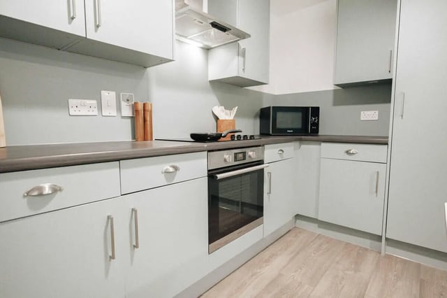 Modern light blue kitchen with oven microwave and cabinets kitchen at Market House in Newcastle Upon Tyne Student Accommodation