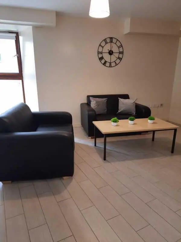 Two black sofas small table clock Living Room at Keiller Court in Dundee Student Accommodation