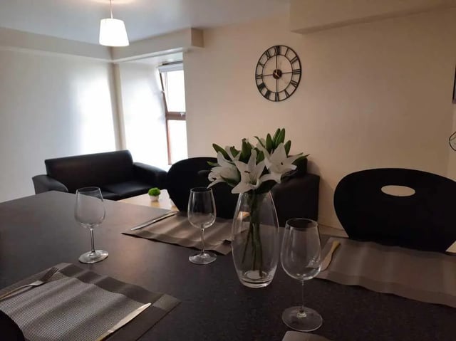 Table setting with flowers and sofas Living room at Keiller Court in Dundee Student Accommodation