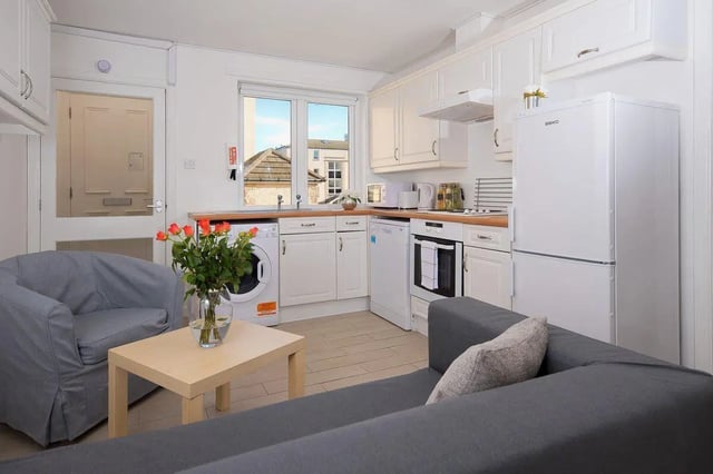 Sofa chairs table washing machine fridge kitchen at Trinity Court in Aberdeen Student Accommodation