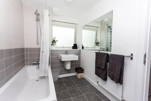 Modern bathroom with tub sink mirror and towels bathroom at King Street 403 in Aberdeen Student Accommodation