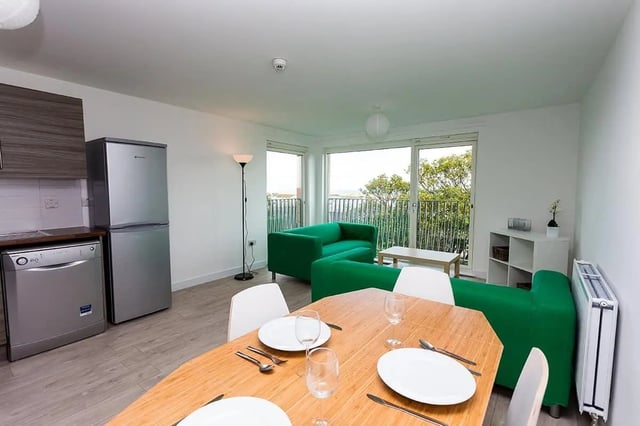 Dining table green sofas modern kitchen living room at King Street 403 in Aberdeen Student Accommodation