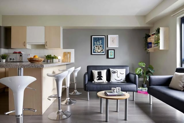 Kitchen island with bar stools and living area living room at St Thomas Court in Plymouth Student Accommodation
