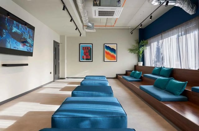 Blue benches and wall mounted TV communal area at Edinburgh Westfield in Edinburgh Student Accommodation