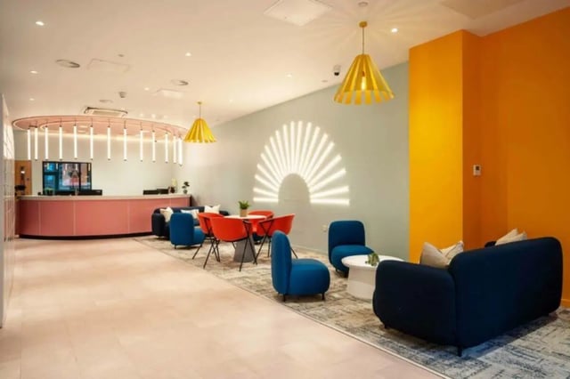 Reception desk blue chairs orange chairs living room at Oxford Point in Bournemouth Student Accommodation