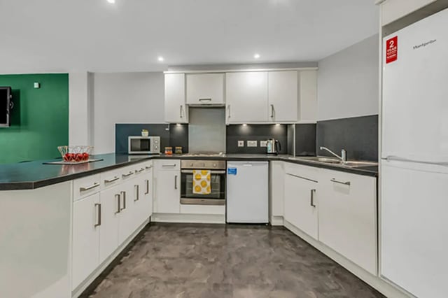 White cabinets microwave oven fridge kitchen at The Triangle in Leeds Student Accommodation