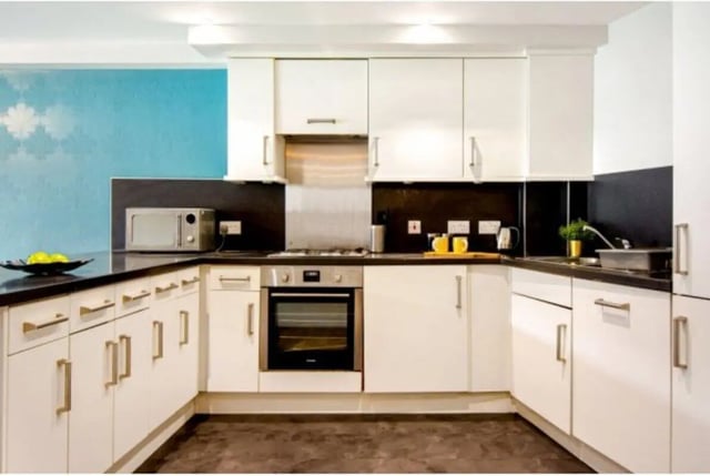 White cabinets microwave oven stove sink kitchen at The Triangle in Leeds Student Accommodation