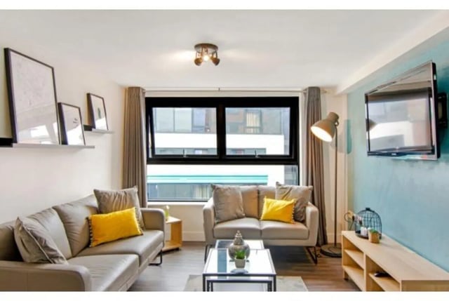 Two sofas yellow pillows glass table living room at The Triangle in Leeds Student Accommodation