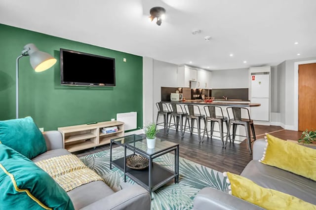 Sofa TV kitchen bar stools and appliances living room at The Triangle in Leeds Student Accommodation