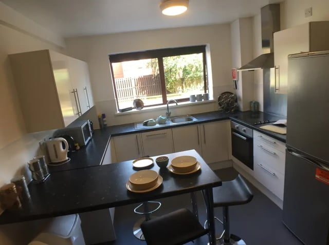 Kitchen with table chairs microwave fridge stove kitchen at Forest Court in Loughborough Student Accommodation