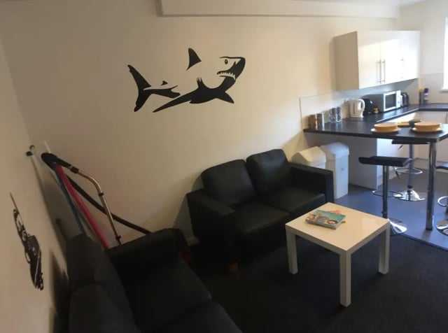 Shark decal sofas white table kitchen counter living room at Forest Court in Loughborough Student Accommodation